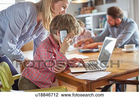Parents and sons working in home office View Large Photo Image Stock Image - Parents and sons working in home office. Fotosearch