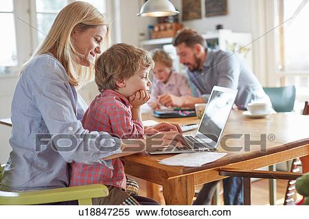 Stock Photography - Parents and sons working in home office. Fotosearch