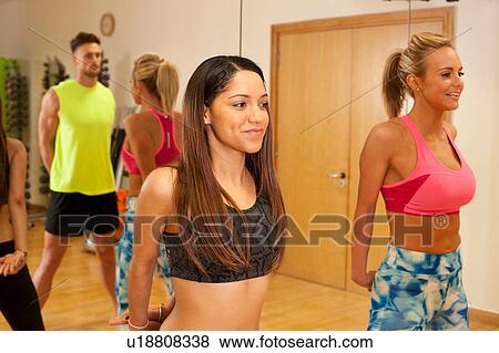 Stock Photo - People in gym, hands behind back exercising. Fotosearch