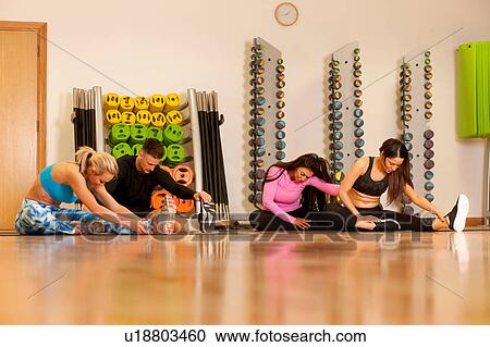 People in gym sitting on floor doing leg stretching exercises View Large Photo Image Stock Image - People in gym sitting on floor doing leg stretching exercises. Fotosearch