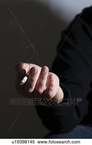 Person holding a cigarette, smoking View Large Photo Image Stock Photography - Person holding a cigarette, smoking. Fotosearch