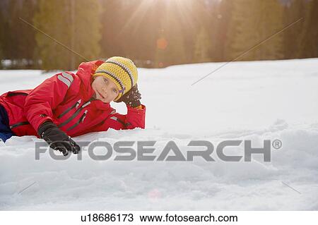 Portrait of boy lying on snow, Elmau, Bavaria, Germany View Large Photo Image Stock Image - Portrait of boy lying on snow, Elmau, Bavaria, Germany. Fotosearch