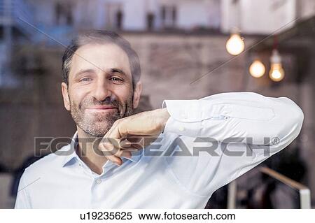 Portrait of businessman leaning against and looking through office window View Large Photo Image Stock Photography - Portrait of businessman leaning against and looking through office window. Fotosearch