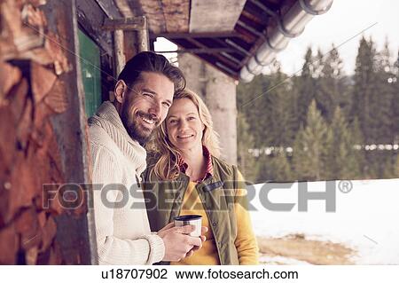 Portrait of couple standing outside log cabin in winter, Elmau, Bavaria, Germany View Large Photo Image Stock Image - Portrait of couple standing outside log cabin in winter, Elmau, Bavaria, Germany. Fotosearch