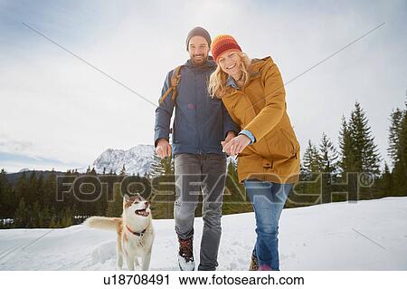 Portrait of couple walking husky in snow covered landscape, Elmau, Bavaria, Germany View Large Photo Image Stock Image - Portrait of couple walking husky in snow covered landscape, Elmau, Bavaria, Germany. Fotosearch