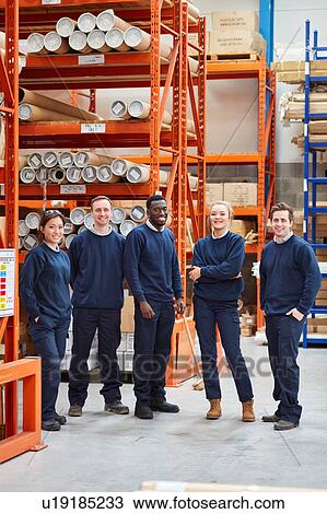 Stock Image - Portrait of factory work team in factory warehouse. Fotosearch