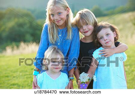 Portrait of four siblings standing in field View Large Photo Image Stock Image - Portrait of four siblings standing in field. Fotosearch