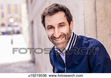 Stock Photograph - Portrait of happy mature man on city sidewalk. Fotosearch