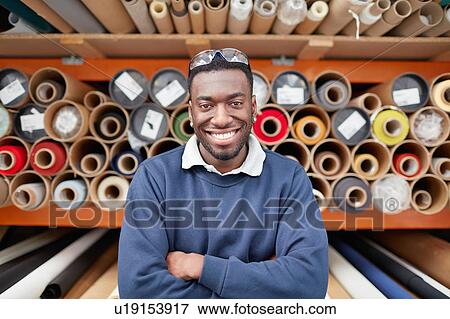 Portrait of male factory worker in front of textile rolls in roller blind factory View Large Photo Image Stock Photo - Portrait of male factory worker in front of textile rolls in roller blind factory. Fotosearch