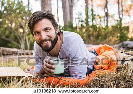 Portrait of man in sleeping bag with coffee in forest, Deer Park, Cape Town, South Africa View Large Photo Image Stock Photo - Portrait of man in sleeping bag with coffee in forest, Deer Park, Cape Town, South Africa. Fotosearch