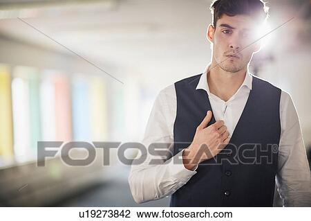 Stock Image - Portrait of man wearing waist coat looking at camera. Fotosearch