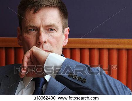 Stock Image - Portrait of mature businessman, pensive expression. Fotosearch