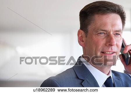Stock Photo - Portrait of mature businessman using smartphone. Fotosearch