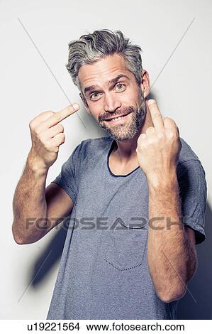 Portrait of mid adult man making obscene hand gestures, smiling View Large Photo Image Picture - Portrait of mid adult man making obscene hand gestures, smiling. Fotosearch