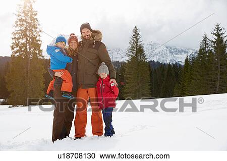 Stock Image - Portrait of parents and sons in snow covered landscape, Elmau, Bavaria, Germany. Fotosearch