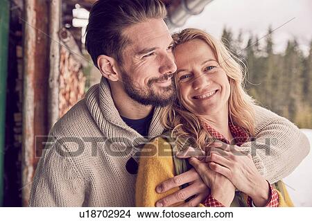 Portrait of romantic couple standing outside log cabin in winter, Elmau, Bavaria, Germany View Large Photo Image Picture - Portrait of romantic couple standing outside log cabin in winter, Elmau, Bavaria, Germany. Fotosearch