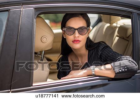 Portrait of stylish businesswoman at backseat car window, Dubai, United Arab Emirates View Large Photo Image Stock Image - Portrait of stylish businesswoman at backseat car window, Dubai, United Arab Emirates. Fotosearch