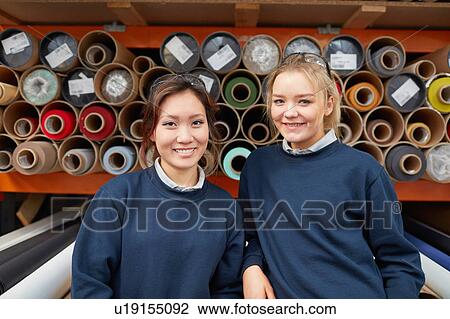 Portrait of two female factory workers in front of textile rolls in roller blind factory View Large Photo Image Stock Image - Portrait of two female factory workers in front of textile rolls in roller blind factory. Fotosearch