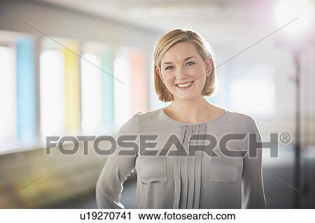Stock Image - Portrait of woman wearing blouse looking at camera smiling. Fotosearch