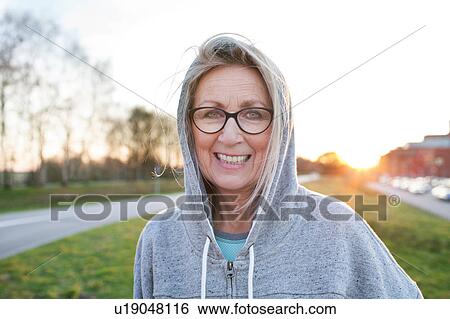 Portrait of woman wearing eyeglasses and hooded top looking at camera smiling View Large Photo Image Stock Photograph - Portrait of woman wearing eyeglasses and hooded top looking at camera smiling. Fotosearch