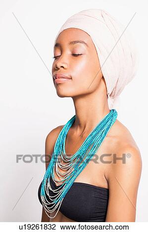 Stock Image - Portrait of woman wearing headscarf and statement necklace. Fotosearch