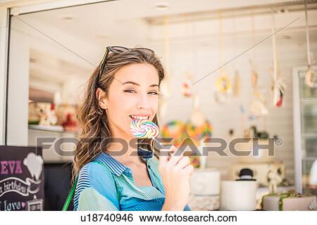 Portrait of woman with lollipop from sweet stall, Dubai, United Arab Emirates View Large Photo Image Stock Photograph - Portrait of woman with lollipop from sweet stall, Dubai, United Arab Emirates. Fotosearch
