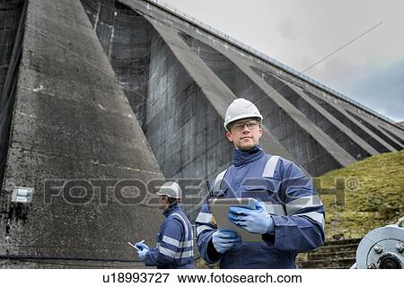 Portrait of worker at foot of dam at hydroelectric power station View Large Photo Image Stock Photo - Portrait of worker at foot of dam at hydroelectric power station. Fotosearch