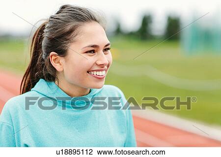 Portrait of young girl on running track, smiling View Large Photo Image Stock Image - Portrait of young girl on running track, smiling. Fotosearch