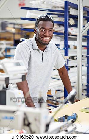 Portrait of young male worker assembling roller blind on production line in factory View Large Photo Image Stock Image - Portrait of young male worker assembling roller blind on production line in factory. Fotosearch