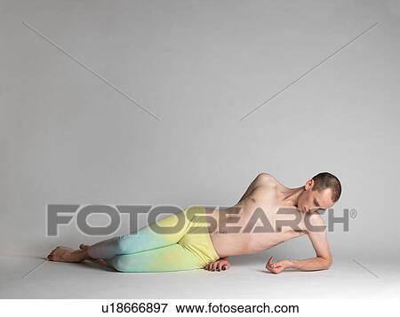 Portrait of young man wearing multi- coloured leggings reclining on studio floor looking down View Large Photo Image Stock Photo - Portrait of young man wearing multi- coloured leggings reclining on studio floor looking down. Fotosearch