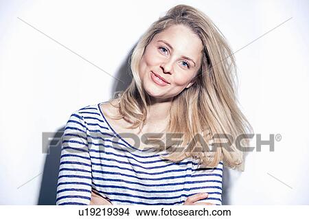 Portrait of young woman, arms folded, smiling View Large Photo Image Picture - Portrait of young woman, arms folded, smiling. Fotosearch