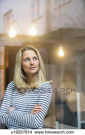 Portrait of young woman, arms folded, looking away View Large Photo Image Picture - Portrait of young woman, arms folded, looking away. Fotosearch