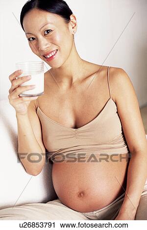 Stock Image - Pregnant woman drinking milk. Fotosearch