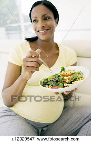 Pregnant woman eating a salad View Large Photo Image Stock Photo - Pregnant woman eating a salad. Fotosearch