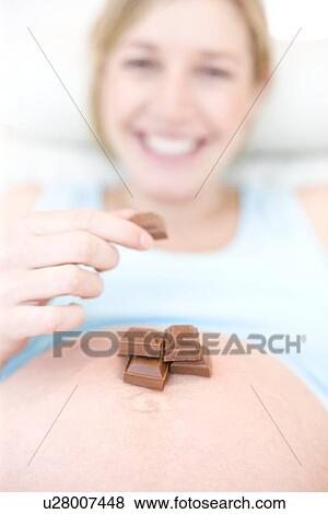 Pregnant woman eating chocolate View Large Photo Image Stock Photo - Pregnant woman eating chocolate. Fotosearch