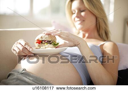 Pregnant woman eating View Large Photo Image Stock Photo - Pregnant woman eating. Fotosearch