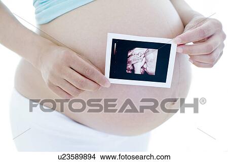 Pregnant woman holding her baby scan View Large Photo Image Picture - Pregnant woman holding her baby scan. Fotosearch