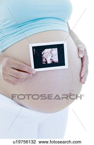 Pregnant woman holding her baby scan View Large Photo Image Stock Image - Pregnant woman holding her baby scan. Fotosearch