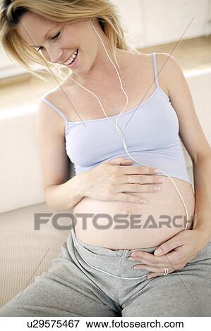 Pregnant woman listening to music View Large Photo Image Stock Photo - Pregnant woman listening to music. Fotosearch
