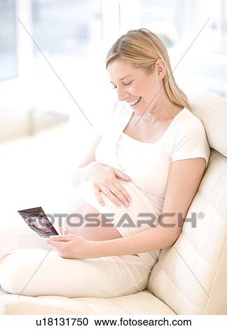 Pregnant woman looking at her baby scan View Large Photo Image Stock Image - Pregnant woman looking at her baby scan. Fotosearch