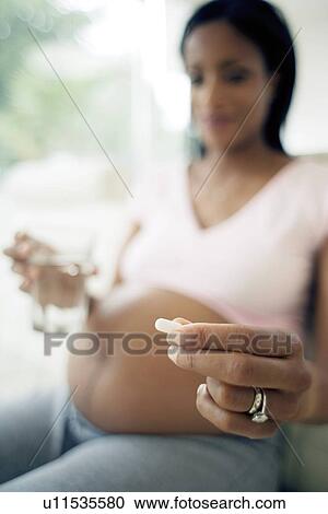 Pregnant woman taking painkillers View Large Photo Image Stock Image - Pregnant woman taking painkillers. Fotosearch