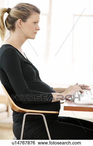 Stock Photograph - Pregnant woman typing. Fotosearch