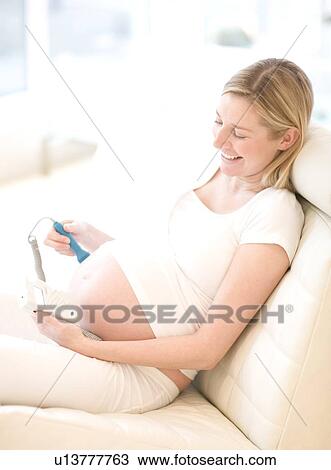 Pregnant woman using a doppler monitor View Large Photo Image Stock Image - Pregnant woman using a doppler monitor. Fotosearch