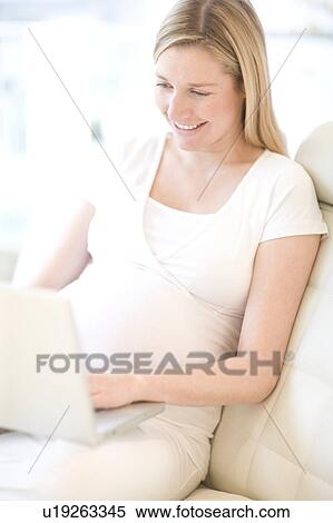 Stock Photography - Pregnant woman using a laptop. Fotosearch