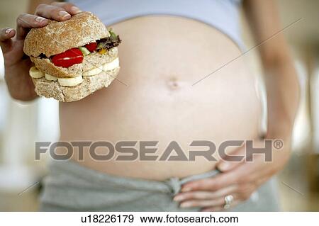 Pregnant woman with a sandwich View Large Photo Image Stock Photo - Pregnant woman with a sandwich. Fotosearch