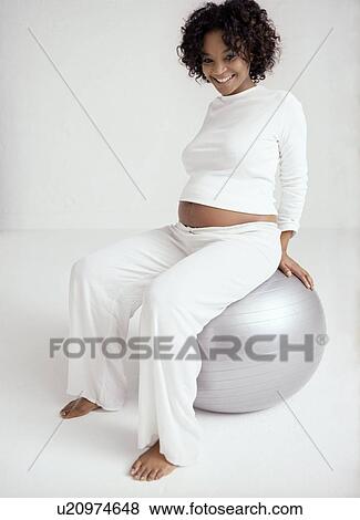 Stock Photo - Pregnant woman with birthing ball. Fotosearch