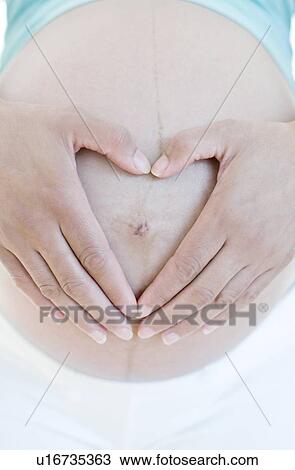 Stock Image - Pregnant woman's abdomen. Fotosearch