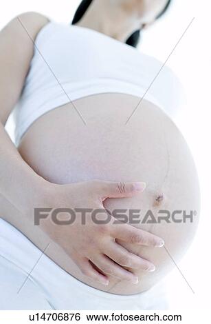 Stock Photograph - Pregnant woman's abdomen. Fotosearch