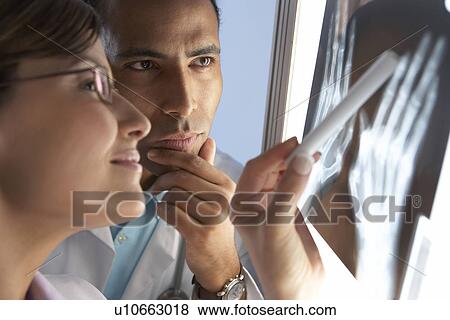 Radiologists examining an X-ray View Large Photo Image Stock Photo - Radiologists examining an X-ray. Fotosearch