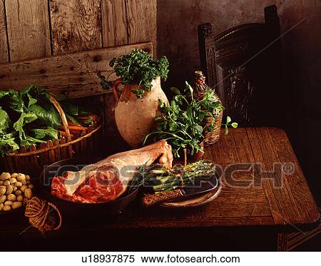 Stock Photography - Raw Leg of lamb, new potatoes, asparagus, spinach, carrots, parsley and mint. Fotosearch